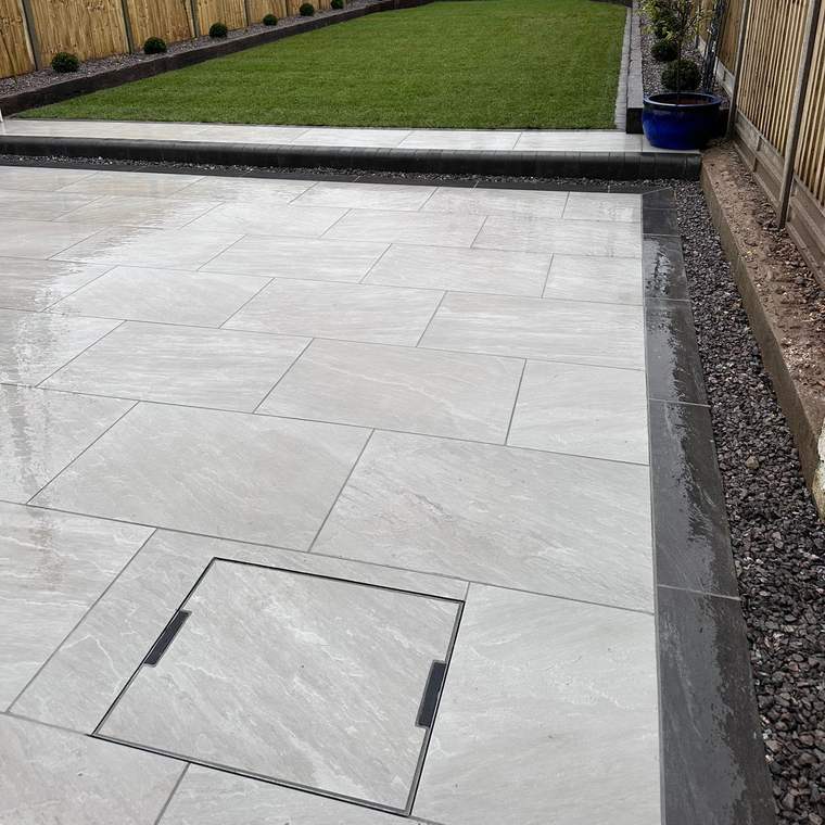 Recessed drainage inspection cover set into new porcelain paving