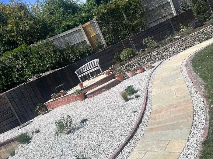 Curved sandstone path through a gravel garden with raised seating area
