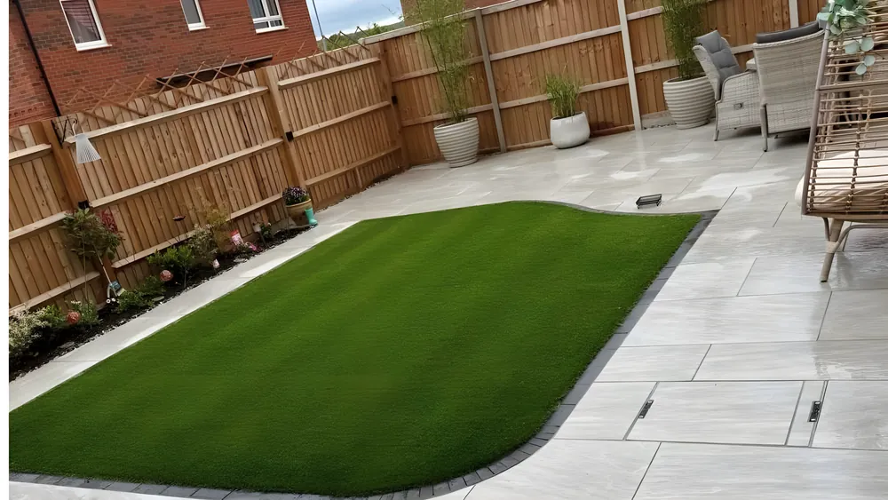 Curved artificial lawn edged by a pale porcelain patio