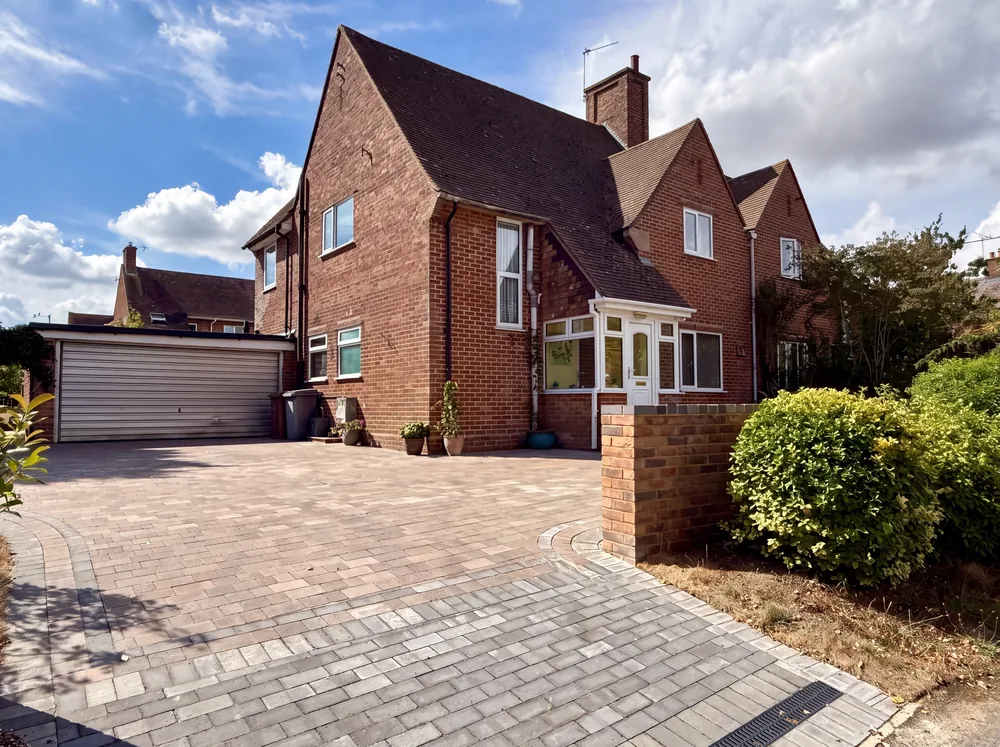 Brindle block paved driveway and path in front of a red brick house
