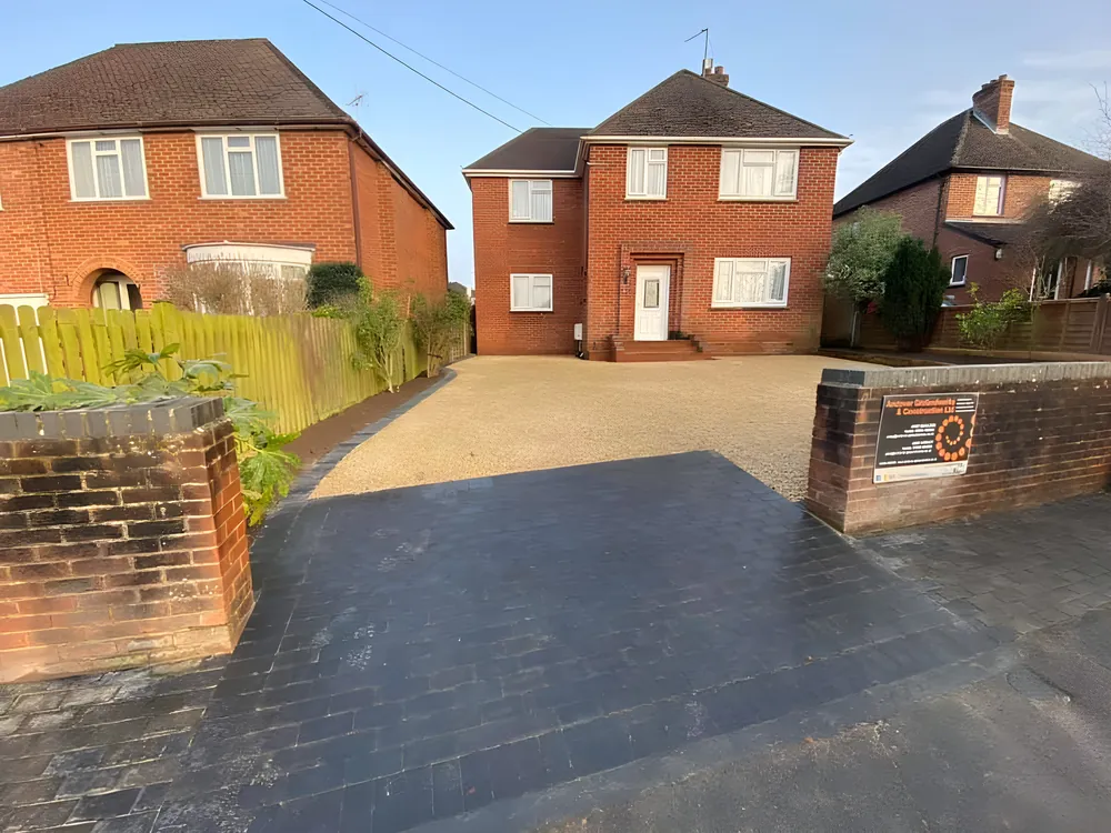 New driveway with brick pillars in front of red brick houses
