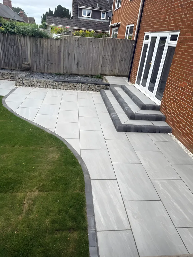 Grey porcelain path and steps curving beside a lawn
