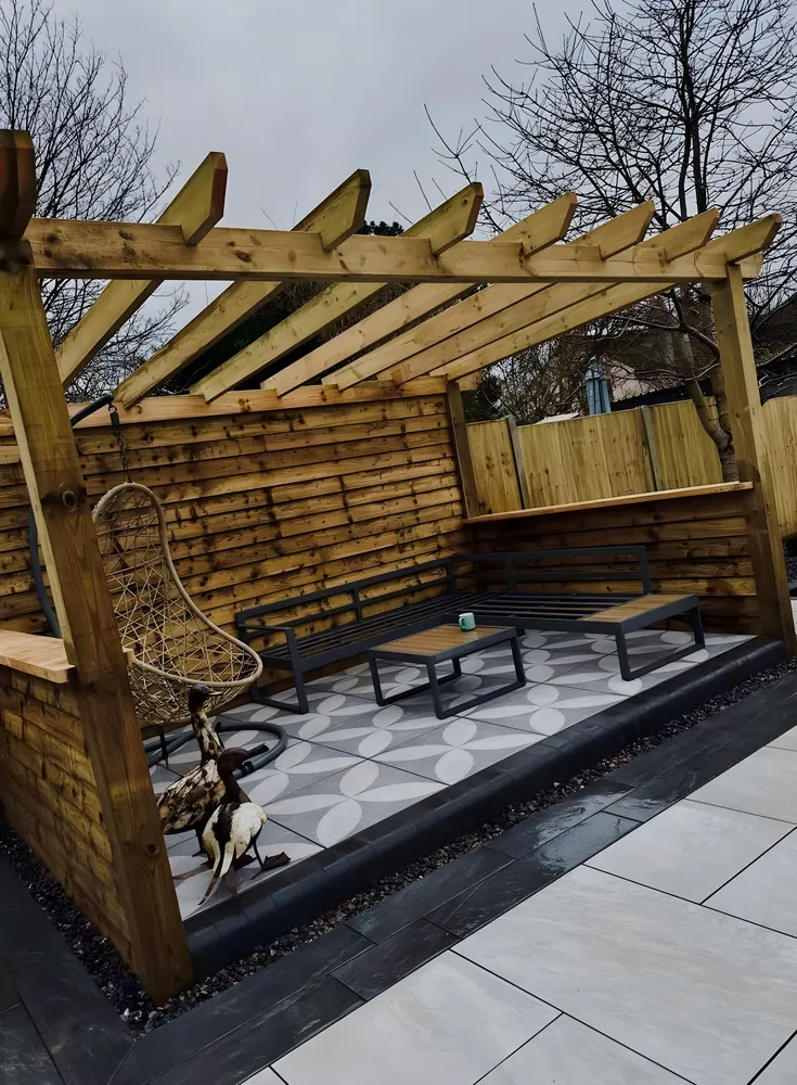 Timber pergola with a hanging seat over a patterned tiled floor