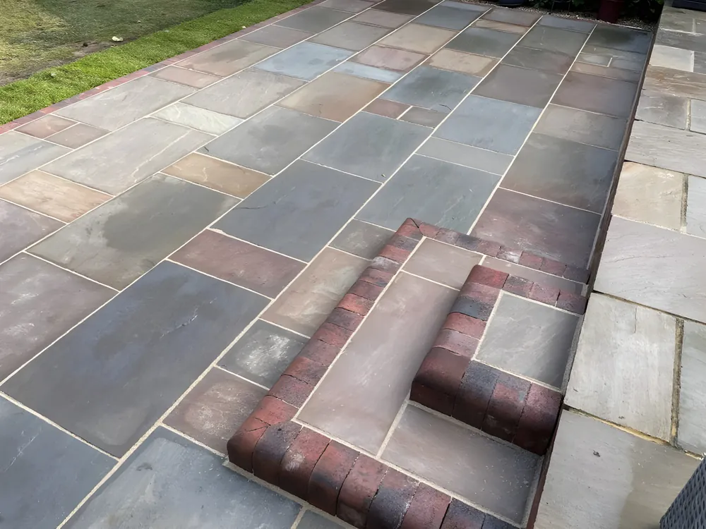 Multi tone sandstone paving with a brick edged step