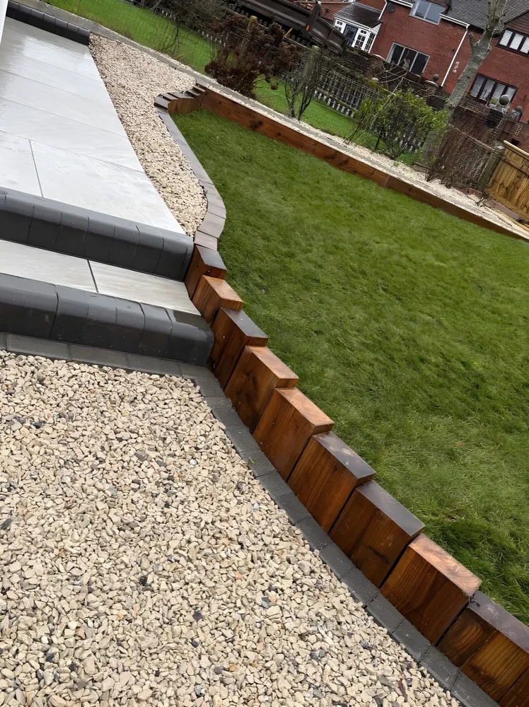 Timber sleeper edging between a lawn and a gravel path